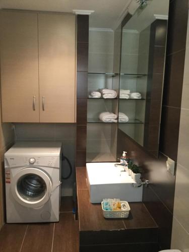 a bathroom with a washing machine and a sink at Seafront apartment ΙΙ in Kiveri, near Nafplion. in Kivérion