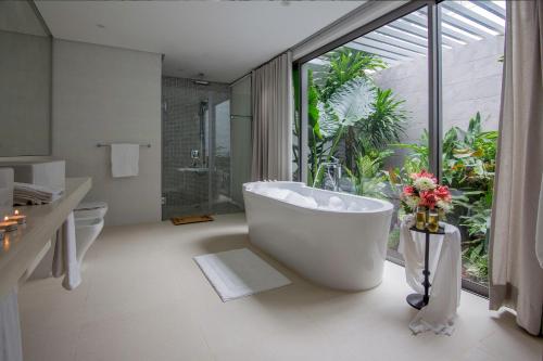 a bathroom with a bath tub and a large window at AquaBlu Villa in Victoria