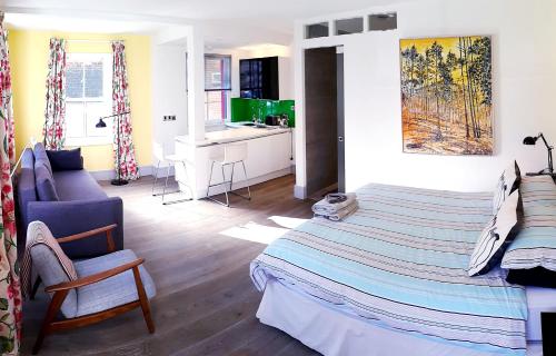 a bedroom with a bed and a chair and a desk at Lake Street Studios in Oxford