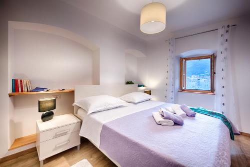 a bedroom with a bed with two towels on it at Demaria apartman u Komiži s pogledom na more in Komiža