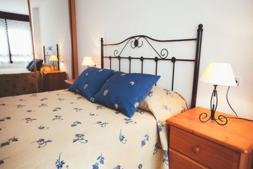 um quarto com uma cama com flores azuis em Espumeru, apartamento en Llanes em Llanes