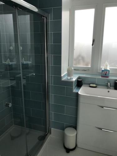 a bathroom with a glass shower and a sink at The Coach House 75 Epsom Road in Guildford