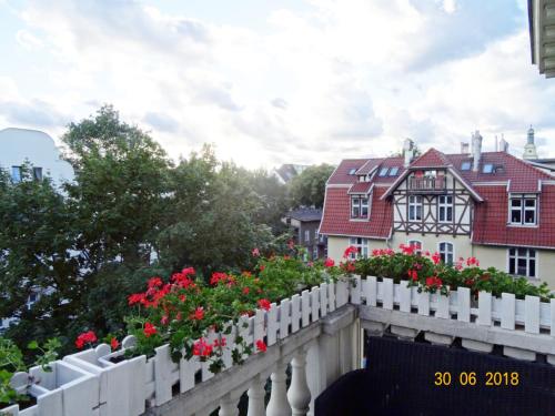 ソポトにあるSopot: apartament closest to the seaの家の上に花の飾り付き白い柵