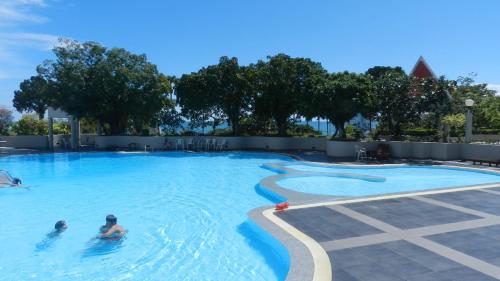 a group of people swimming in a swimming pool at Jomtien PLAZA Condotel in Jomtien Beach