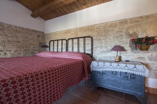 a bedroom with a bed and a table with a lamp at MASSERIA CITULO Il Pino grande in Castel del Monte