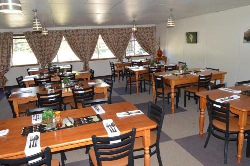 a dining room filled with wooden tables and chairs at Motebong Lodge in Bokong