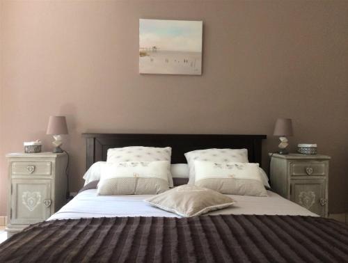 サンテステフにあるChateau Haut Baronの大きなベッドと2つのナイトスタンドを備えた寝室