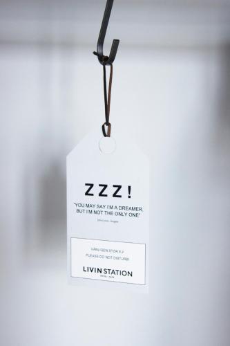 a light hanging from a ceiling with a sign on it at Livin Station Hotel in Örebro