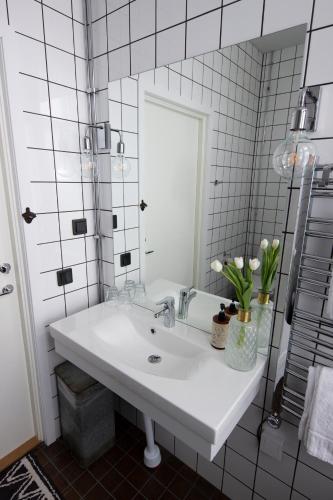 a white bathroom with a sink and a mirror at Livin Station Hotel in Örebro