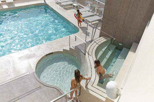 two women are standing in a swimming pool at Hotel Continental & Residence in Gabicce Mare