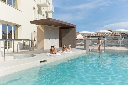 un grupo de mujeres sentadas en la piscina de un hotel en Hotel Continental & Residence, en Gabicce Mare
