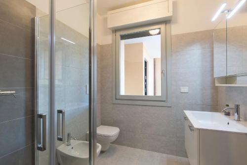 a bathroom with a toilet and a sink and a shower at Baveno Hills | Lakeview apartments in Baveno
