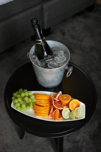 a plate of fruit and vegetables and a bottle of wine at Hotell Hjalmar in Örebro