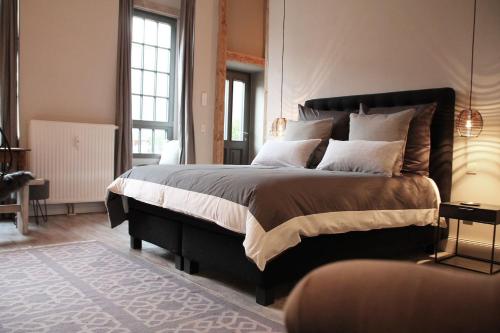 ein Schlafzimmer mit einem großen Bett in einem Zimmer mit Fenstern in der Unterkunft Exklusive Designferienwohnung The Backyard TBY 02 in Trier