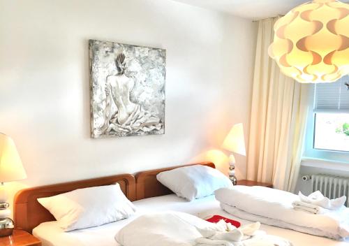 dwa łóżka w pokoju z obrazem na ścianie w obiekcie Fewo Schneewittchen w mieście Mittenwald