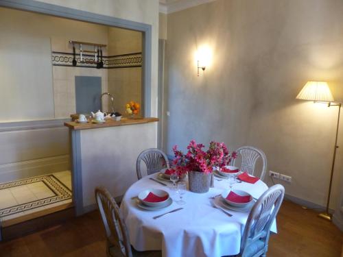uma mesa com uma toalha de mesa branca e flores sobre ela em Résidence Charles Quint em Besançon