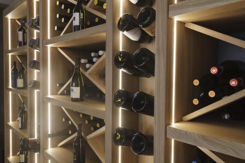 a wall of wine bottles in a wine cellar at TiAMo Modern Design Guest House in Ronchi dei Legionari