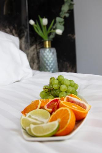 a plate of fruit and grapes on a table at City Central Hotel Örebro by First Hotels in Örebro