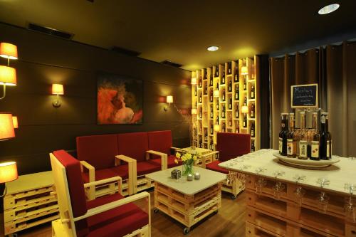 a restaurant with red chairs and a table with bottles of wine at Bio Hotel Panorama in Malles Venosta