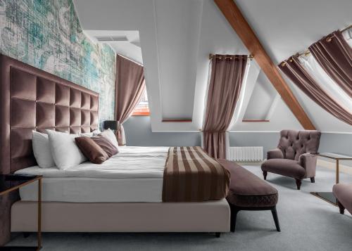 モスクワにあるヴィラ カダシ ブティック ホテルのベッドルーム(大型ベッド1台、椅子付)