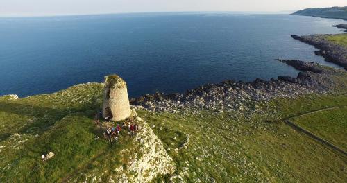 a group of people standing on top of a hill near the ocean at Trapetum-Salento domus in Cursi