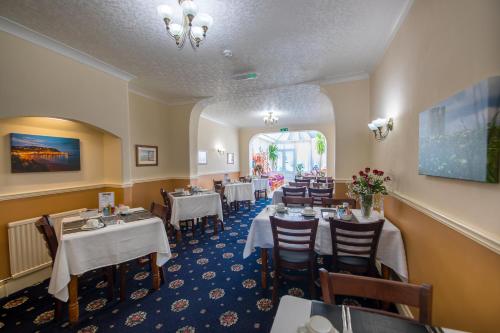 a dining room with tables and chairs in a restaurant at Toulson Court in Scarborough