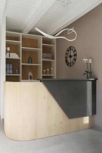 a kitchen with a counter and a clock on the wall at TiAMo Modern Design Guest House in Ronchi dei Legionari