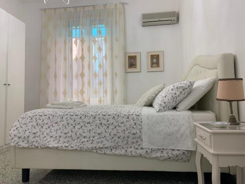 a bedroom with a white bed and a window at Temporary House Oberdan in Bologna