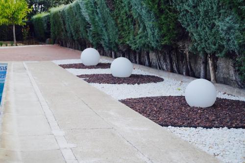 a garden with white egg sculptures on the ground at La Aldea in Aldea del Fresno