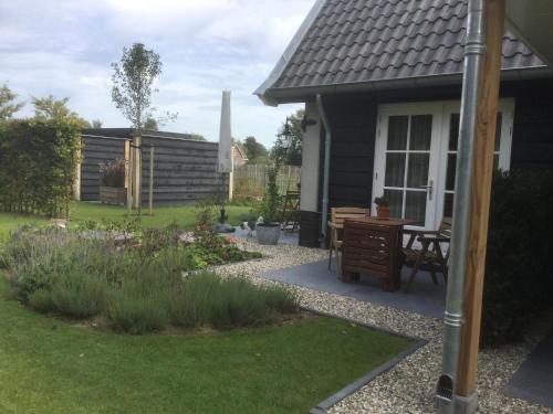 een tuin buiten een huis met een bureau in de tuin bij Logement ‘t Voorhuysch in Ingen