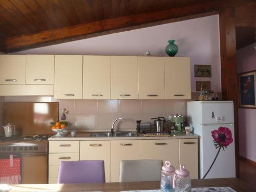 a kitchen with white cabinets and a sink and a refrigerator at 'O Chalet in Pozzuoli