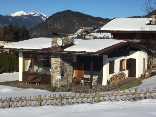 a house in the snow with a fence at Wohlfühlchalet Tirol in Reith im Alpbachtal