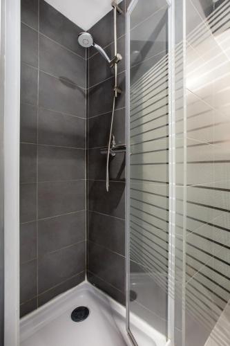 une douche avec une porte vitrée dans une salle de bain dans l'établissement Charmant appartement au coeur du Vieux Lille, à Lille