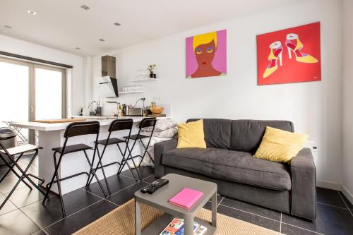 a living room with a couch and a kitchen at Charmant appartement au coeur du Vieux Lille in Lille