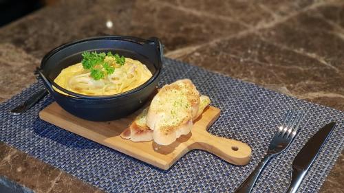 a bowl of soup and a sandwich on a wooden plate at Aurico Kata Resort & Spa - SHA Extra Plus in Kata Beach