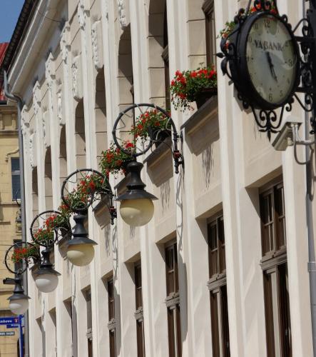 a clock on the side of a building with lights at Hotel Vabank in Golub-Dobrzyń