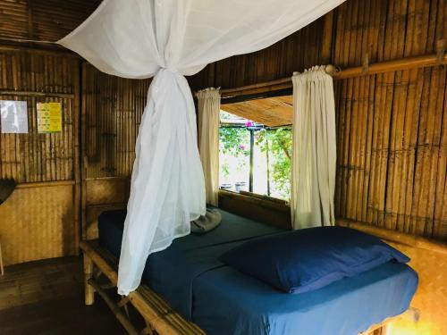 ein Schlafzimmer mit einem Himmelbett und einem Fenster in der Unterkunft Green View Beach Resort in Ko Lipe
