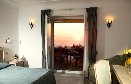 a bedroom with a door open to a patio with a table at Da Gelsomina in Anacapri