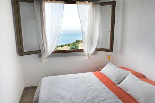 a bedroom with a bed and a window with a view at Arromaniu in Nebida