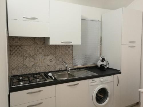 a kitchen with a sink and a washing machine at A casa di Zia Caterina in Zambrone