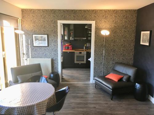 a living room with a table and chairs and a kitchen at Superbe appartement contemporain in Le Touquet-Paris-Plage