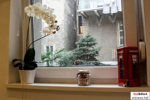 una ventana con una cabina de teléfono roja y un árbol de Navidad en Red & Black Apartment, en Zagreb