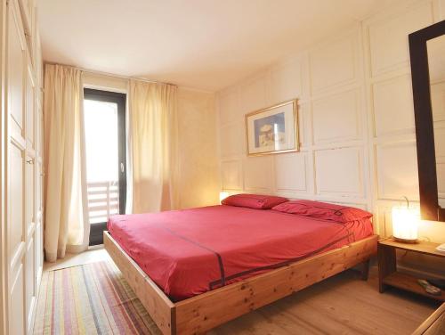 a bedroom with a red bed with a window at Design loft ski in ski out in La Thuile