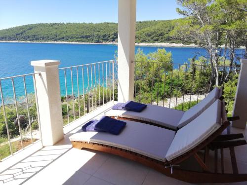 a balcony with a bed and a view of the water at Villa Putto in Vela Luka