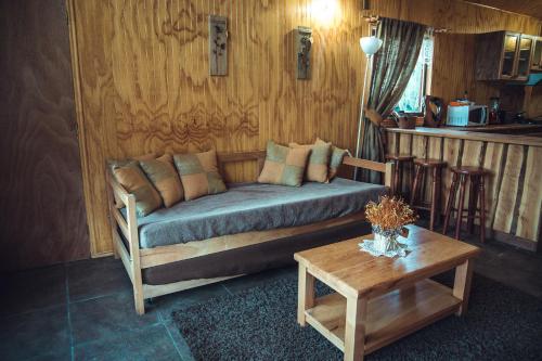 a living room with a couch and a table at Cabañas Shangrila Aysen in Puerto Aisén