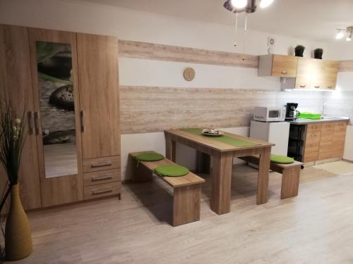 哈卡尼的住宿－Orchidea apartman，厨房配有桌子、两张长椅和一张桌子