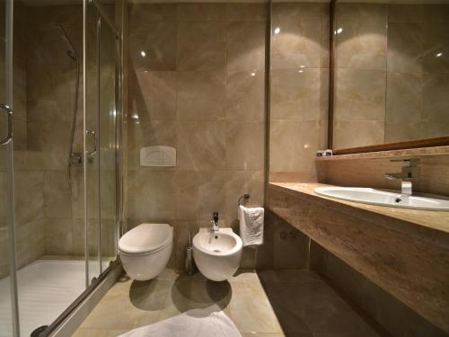 a bathroom with a toilet, sink, and bathtub at Hotel Doro City in Tirana