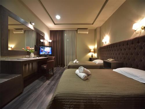 una camera d'albergo con due letti e una televisione di Hotel Doro City a Tirana