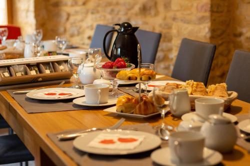 een tafel met eten en borden met eten erop bij Aux Bories de Marquay, chambres d'hôtes B&B avec piscine et SPA près de Sarlat in Marquay
