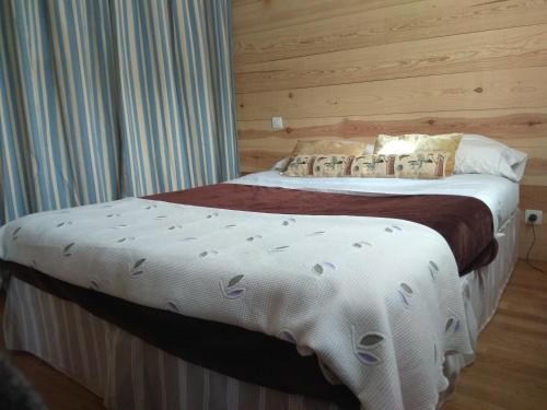 1 dormitorio con 1 cama grande con sábanas blancas en Casa de campo sierra de la demanda en Barbadillo de Herreros